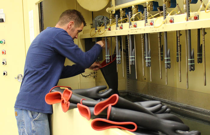 OPPD employee hangs rubber gloves in the machine prior to testing them for leaks