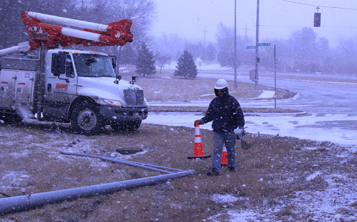OPPD line technician places cones before he repairs a fallen power pole during a troubleshooter call.