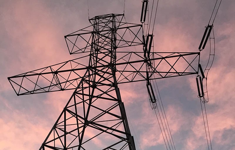 aerial inspections, transmission tower against a sunset