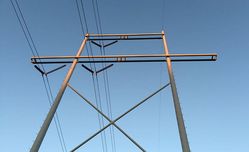 locating transmission lines, a transmission line tower shot from the ground up in perspective