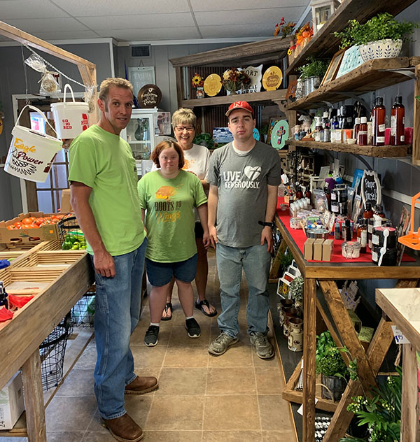 OPPD employee volunteer, Tyler Christensen, left, of OPPD with participants in Roots to Wings inside the organization's store in Arlington, Neb.