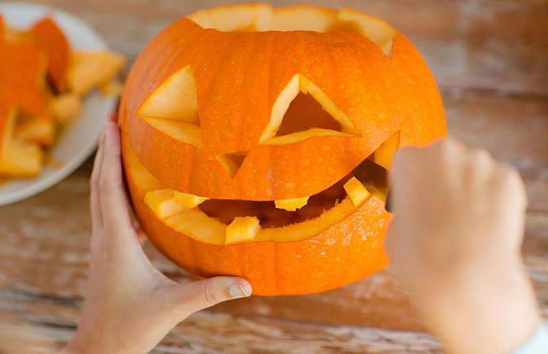 close up of woman with pumpkins at home