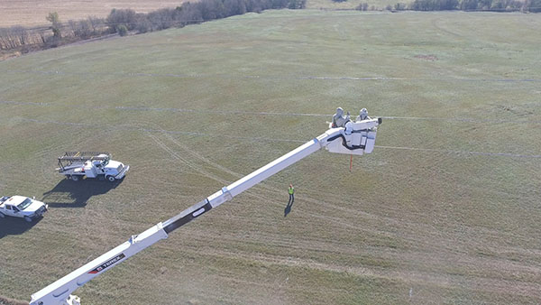 energized transmission work, bucket extended above a transmission line