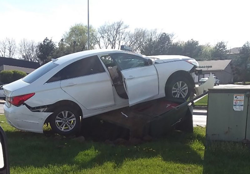 A vehicle sits atop a switchgear box following an accident in Omaha, Nebraska., vehicles causing power outages