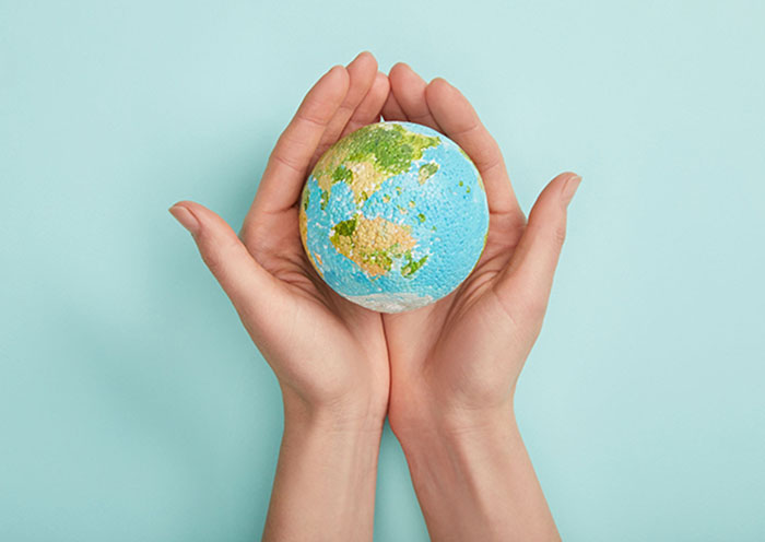 top view of woman holding planet model on turquoise background,